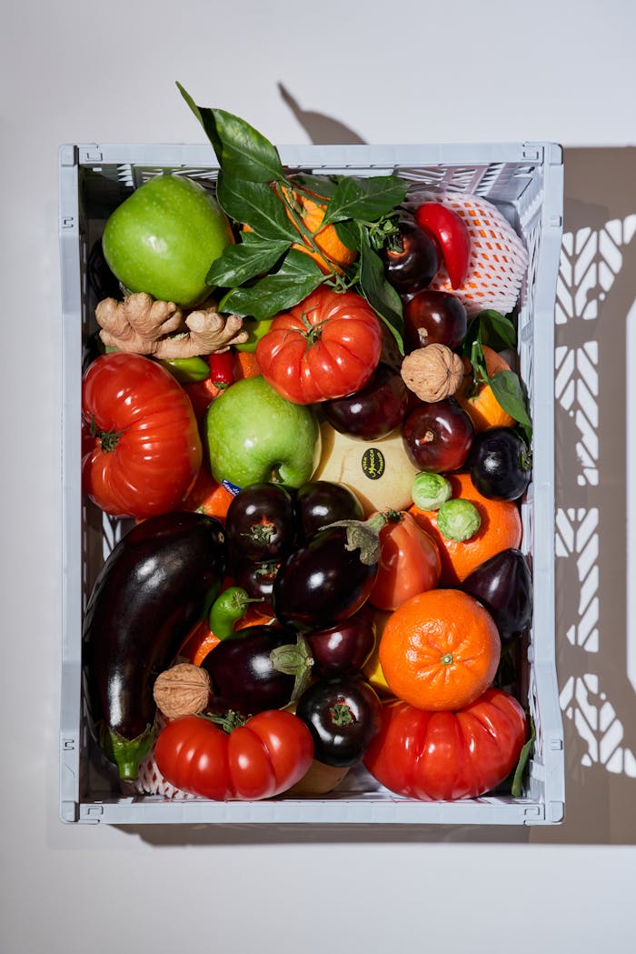 An overhead view of colorful fruits and vegetables arranged in a basket, ideal for promoting healthy eating.
